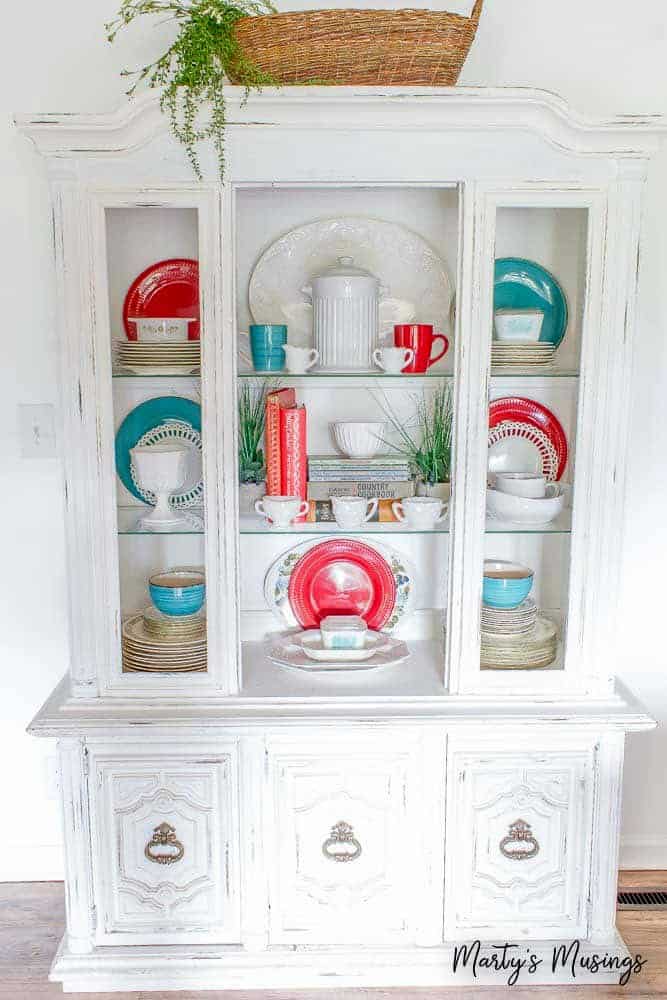 White china hutch filled with red and blue china