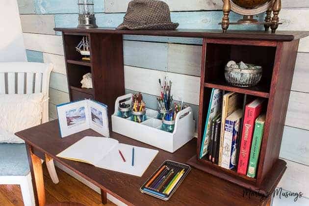 Mahogany desk with drawing supplies and books