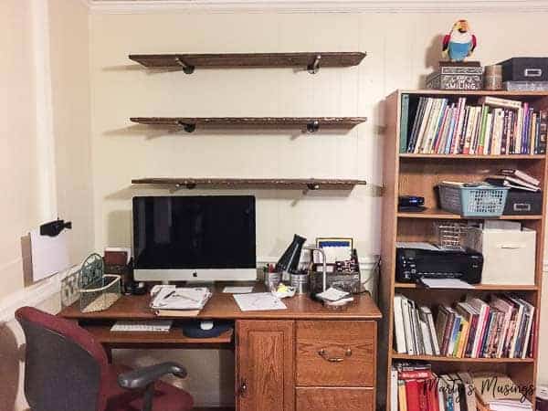 A desk with a book shelf filled with books