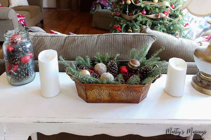 Table with ornaments and greenery nestled in copper container 