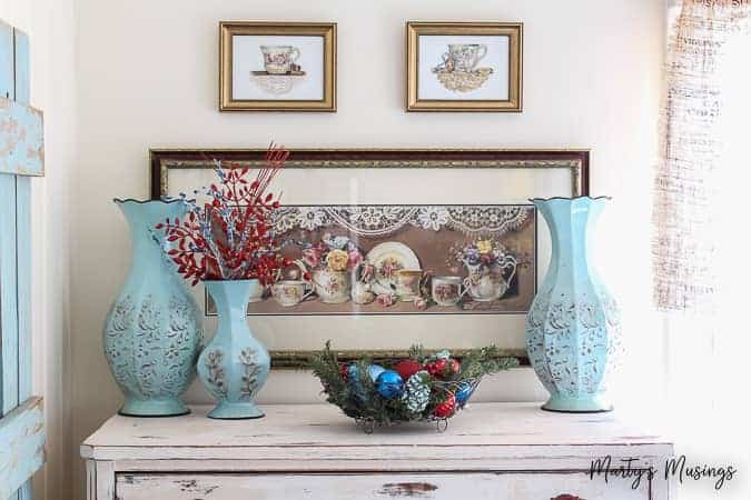 Top of chest with aqua textured vases and metal container with Christmas ornaments