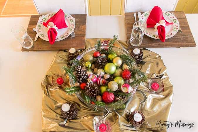 Large punch bowl filled with Christmas ornaments and greenery