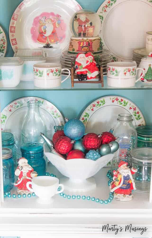 China hutch filled with Christmas ornaments and decorations