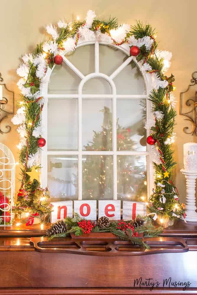 Cathedral window with greenery and white ribbon around it for Christmas