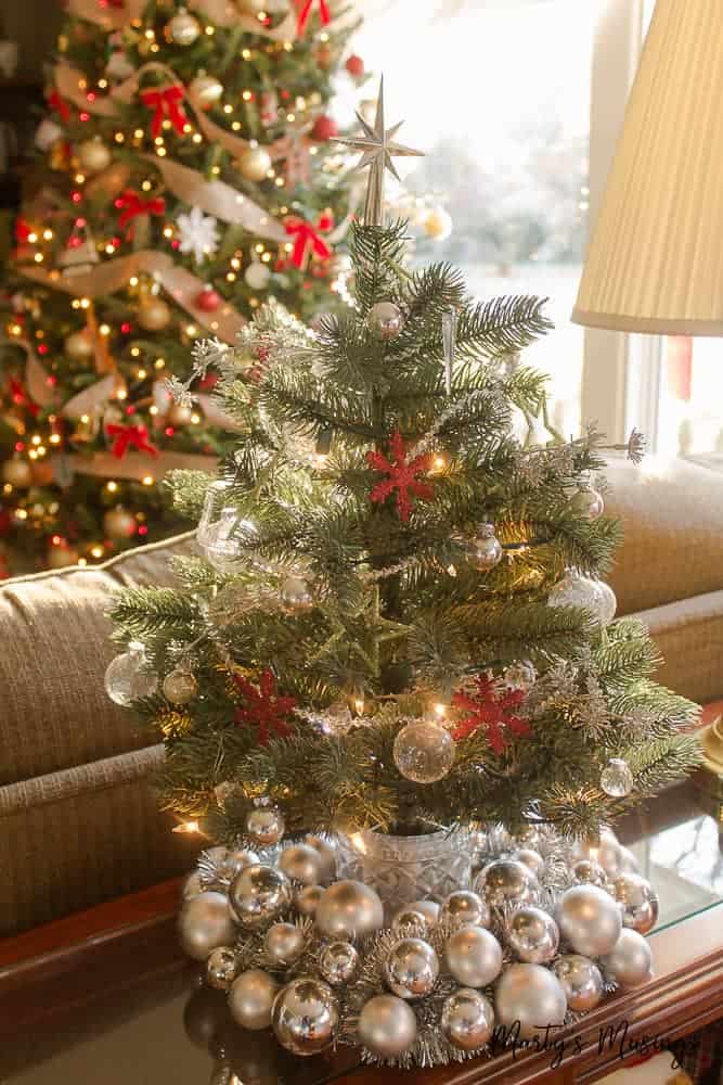 Small christmas tree set on top of silver ornament wreath