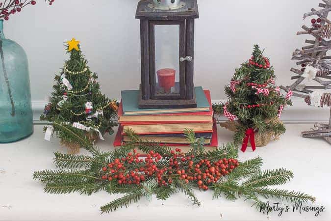 A vase of flowers next to a christmas tree