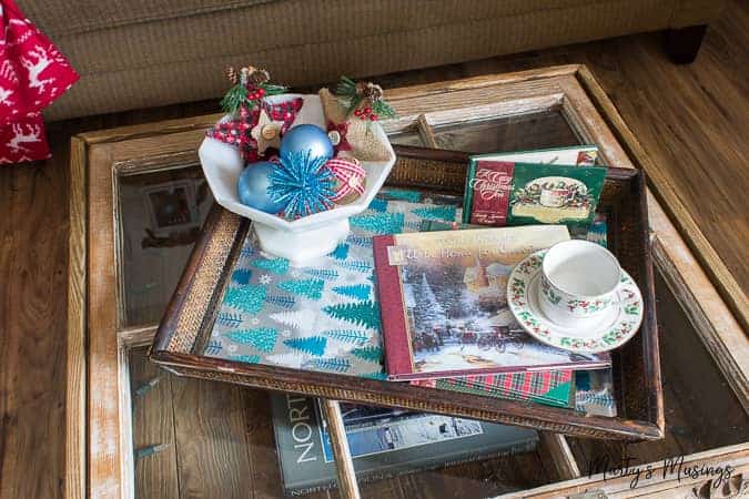 Window table with tray and blue and red Christmas ornaments in bowl