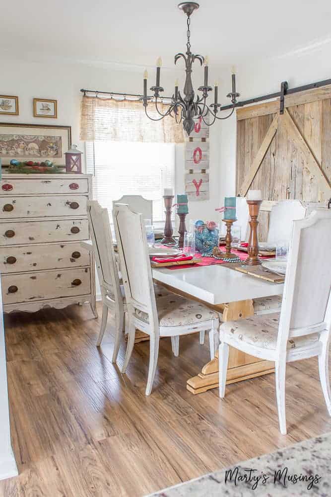 White farmhouse kitchen table with Christmas decorations and rustic barn door