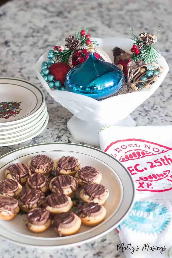 White bowl filled with ornaments and plates with cookies