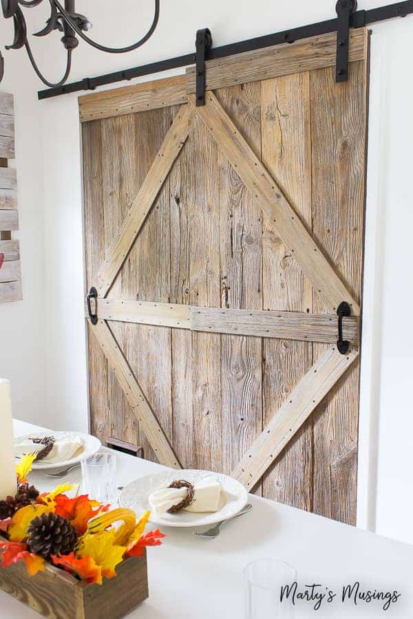 Learn how to build a sliding barn door (complete with a pet door!) with this step by step tutorial. #barnwood #DIY #barndoor #repurposed #rustic #fixerupper #martysmusings