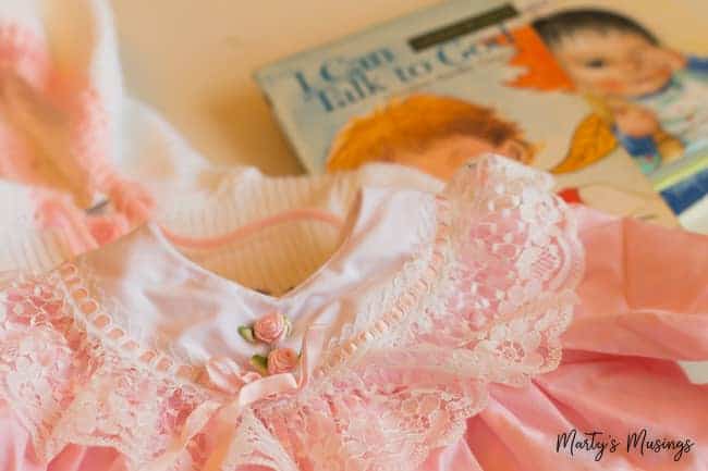 Pink and white baby dress with baby book