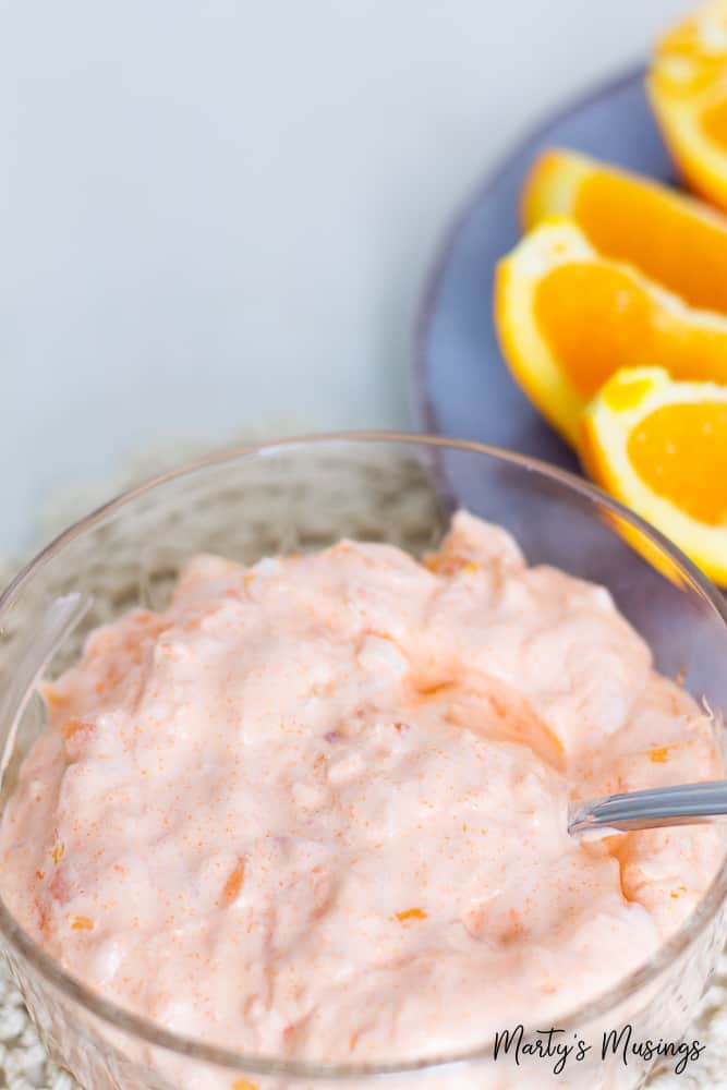 Orange fluff jello salad in crystal dish