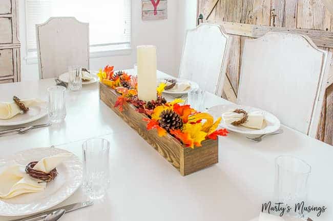 White kitchen table with wooden box centerpiece and barn door