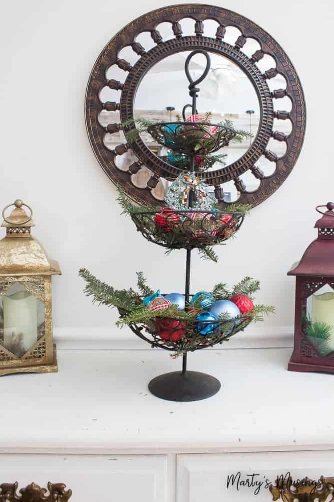 red and blue ornaments on stand with greenery