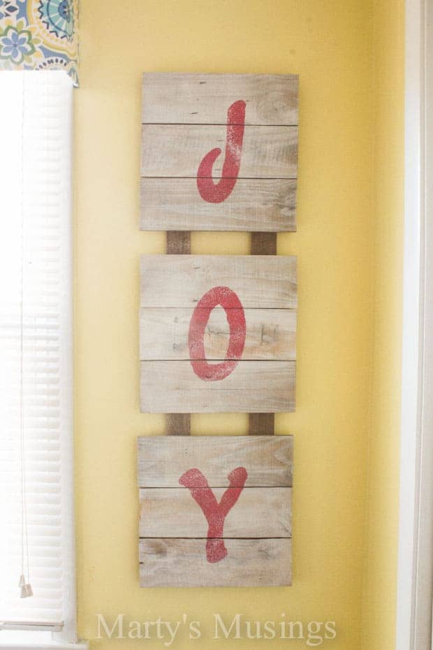 Wooden sign with JOY in stenciled letters