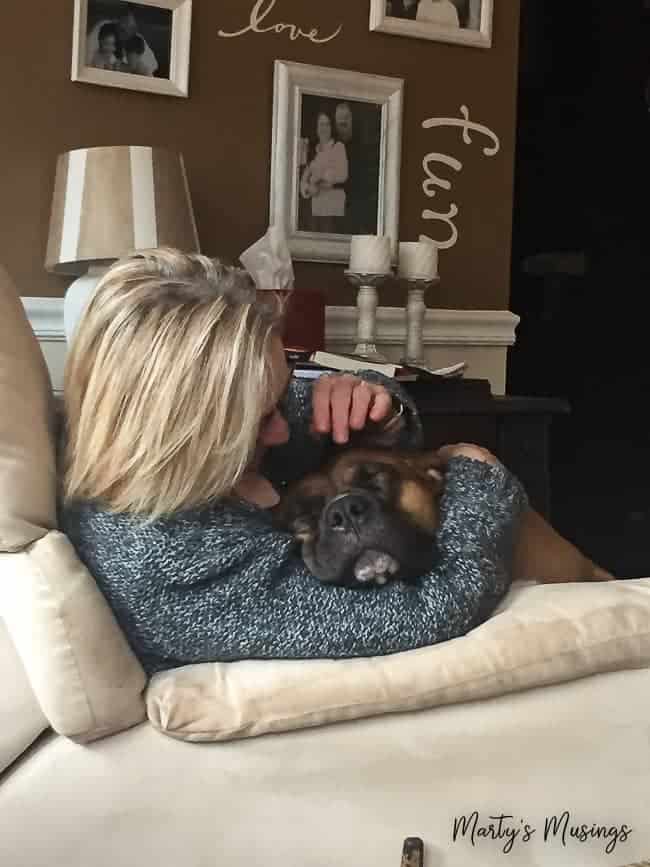 blonde haired woman snuggling with dog in recliner