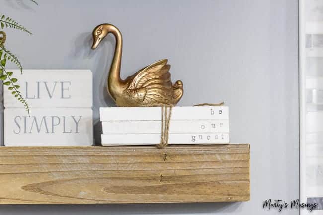 Wooden shelf with stamped books reading be our guest