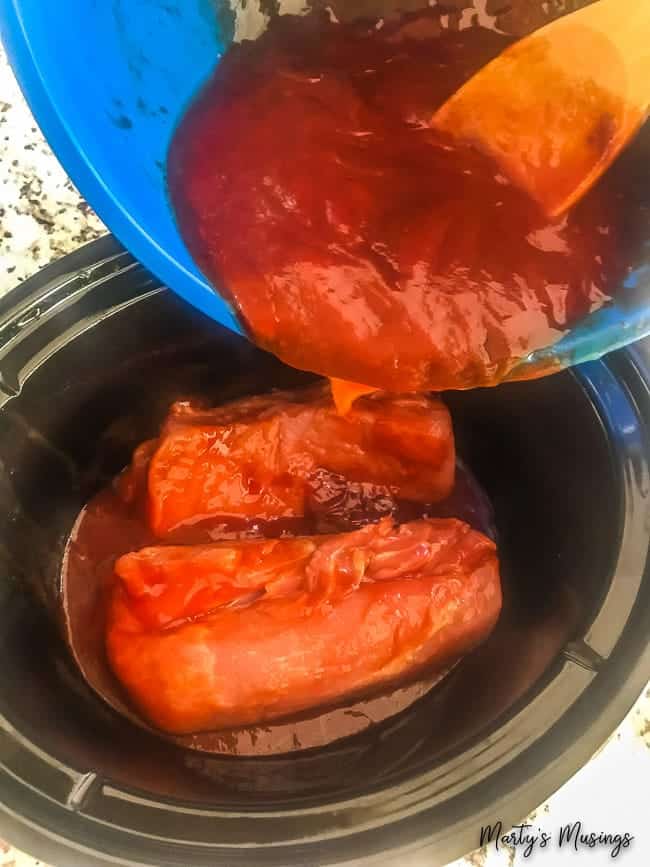 A blue bowl filled with meat and red sauce