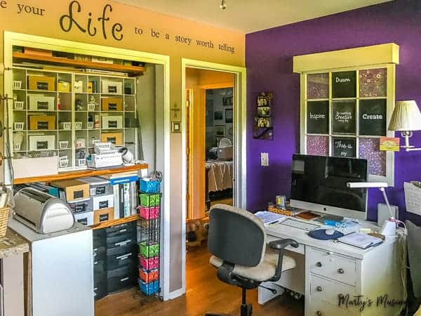 purple craft room accent wall with desk and closet storage