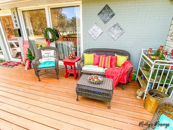 front porch decorated for Christmas with red and blue