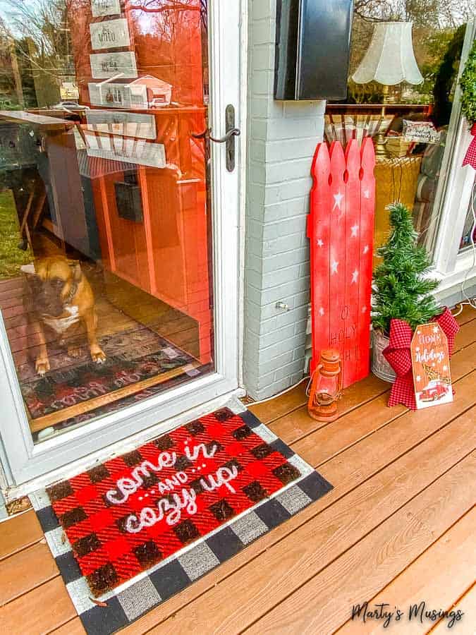 buffalo check layered rugs and Christmas decorations by front door