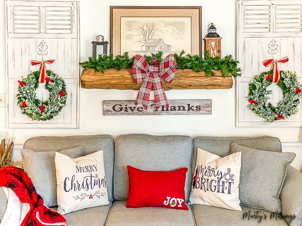 Red and green Christmas decorations with rustic mantel and wreaths