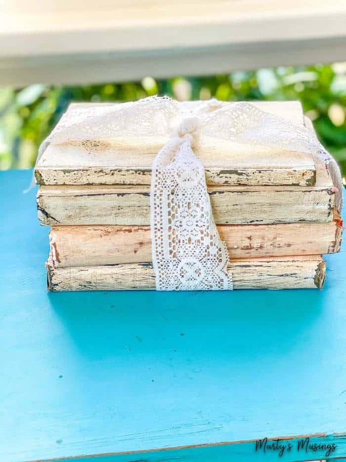 Old books chalk painted and distressed and tied with white lace ribbon