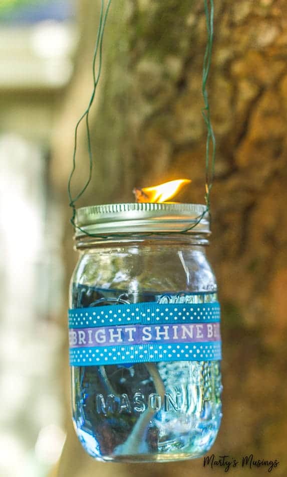 Mason jar with citronella liquid hanging from tree