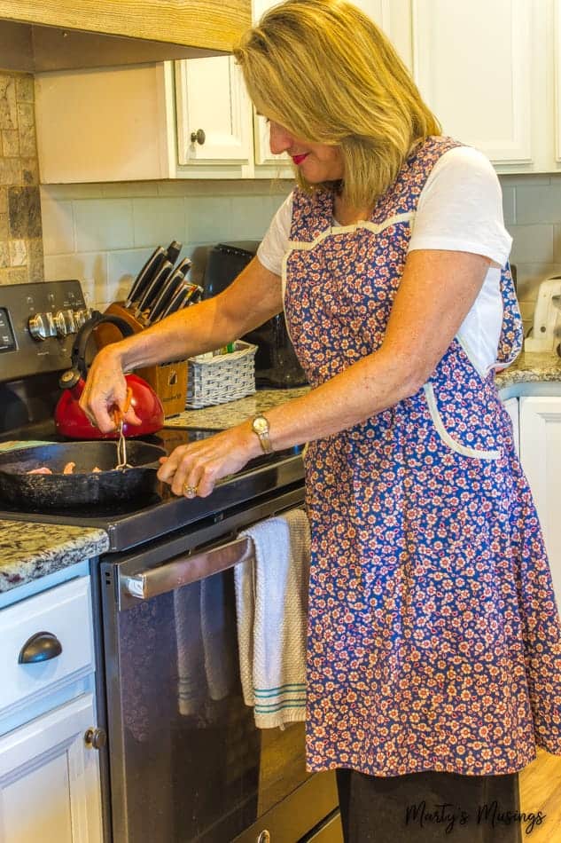 A woman standing in a kitchen preparing food