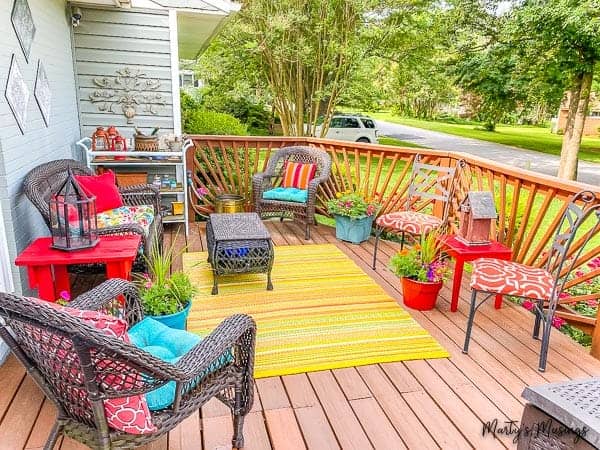 Front deck filled with colorful pillows, planters and rug