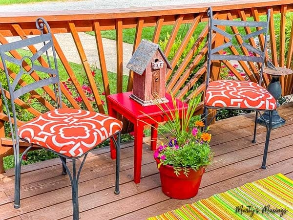 metal chairs with orange fabric and red table with flowers