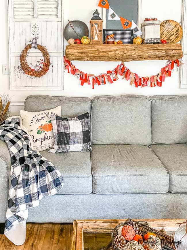 White shutters with wreaths and barnwood mantle with fabric banner and buffalo check fall decor