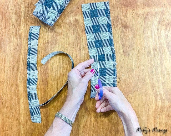 Buffalo check ribbon being cut with scissors