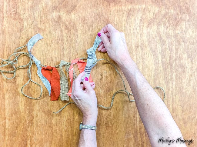 tie strips of fabric onto piece of rope