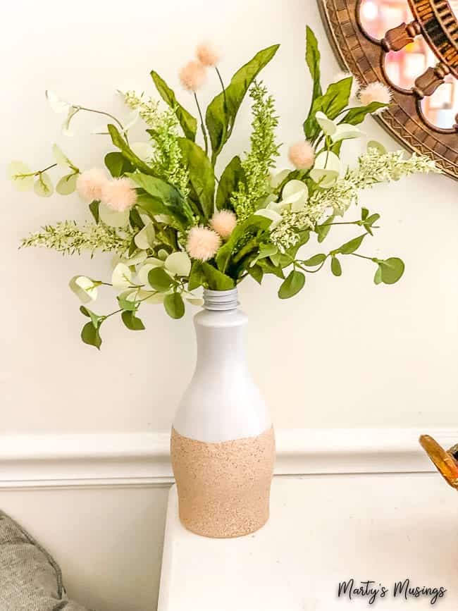 White and stone vase with green stems