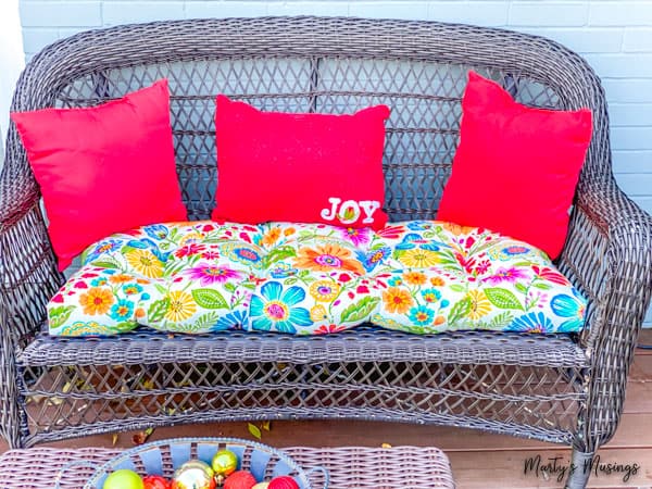 front porch Christmas decorations with red pillows and floral seating