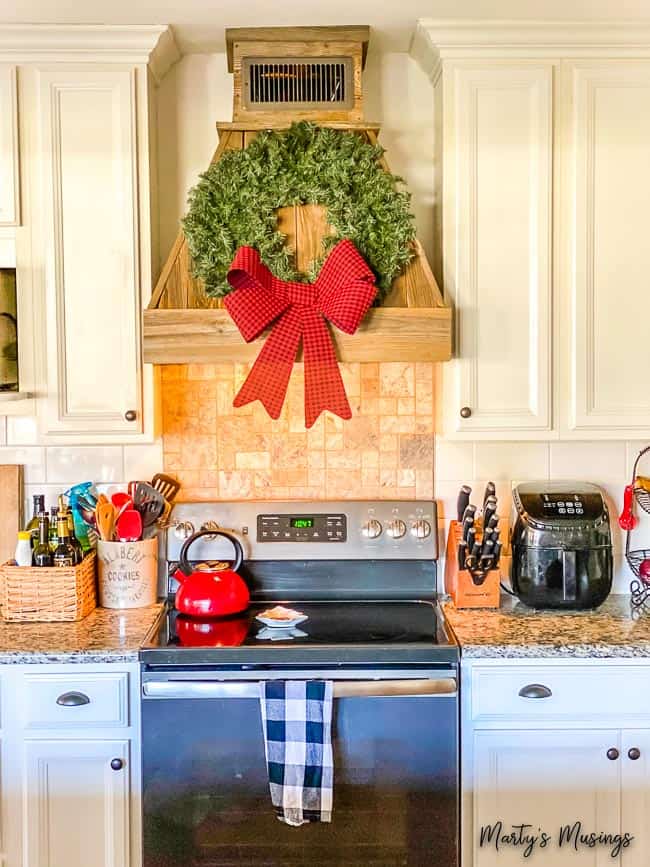 Simple green wreath hanging on barn wood vent in kitchen