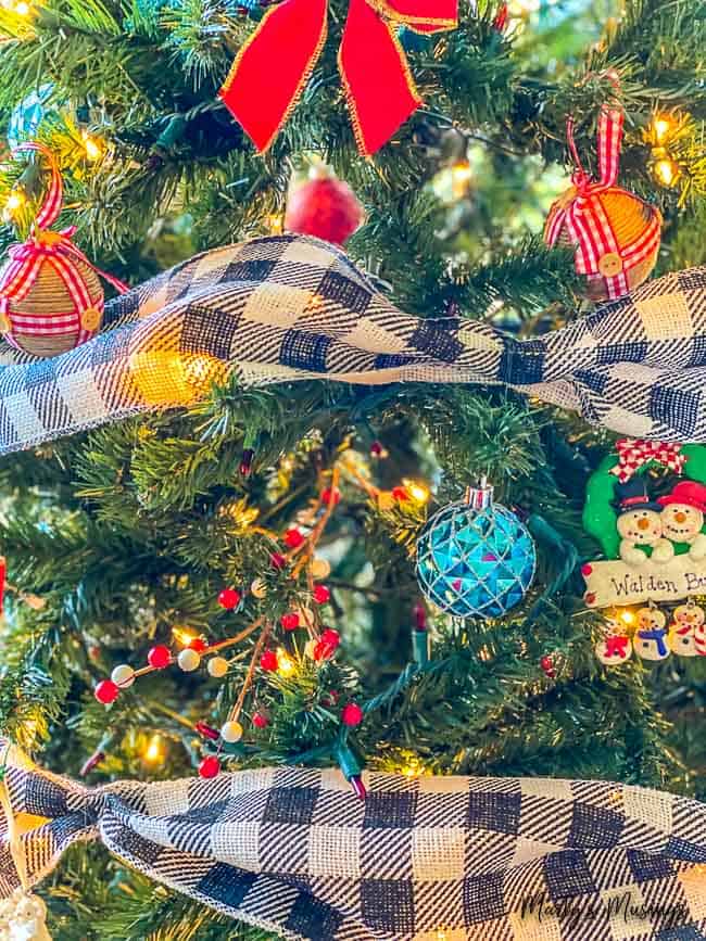 closeup of Christmas tree decorated with black and white checked ribbon and red and blue accents