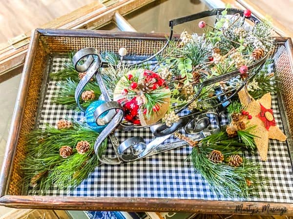 black and white buffalo plaid tray with metal sleigh filled with greenery and burlap ornaments