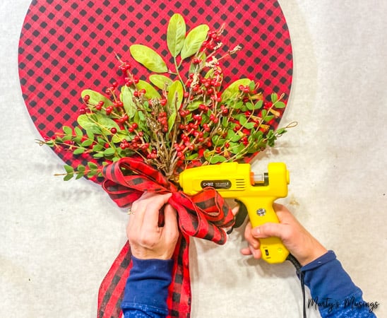 hot glue buffalo plaid bow to DIY wood hoop wreath