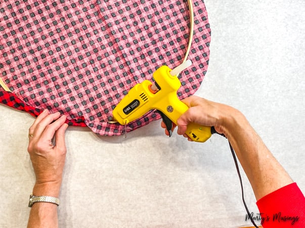 hot glue edges of buffalo plaid hoop wreath