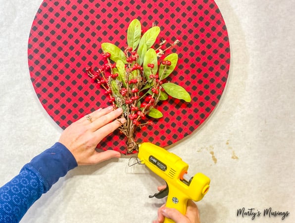 hot glue floral stems to buffalo plaid hoop wreath