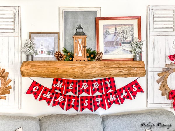 Merry Christmas banner in red and black buffalo check under a rustic mantel