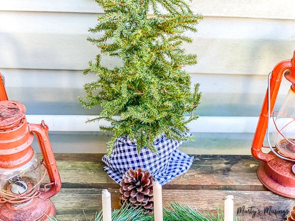 mini Christmas tree wrapped in black and white checked fabric outdoors