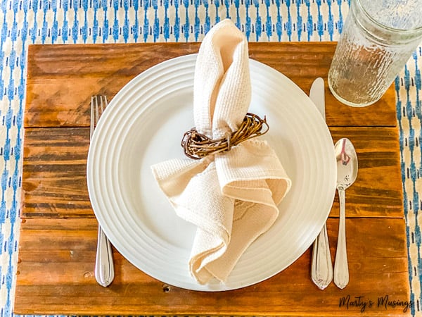 Rustic wood charger with white plates and blue tablecloth