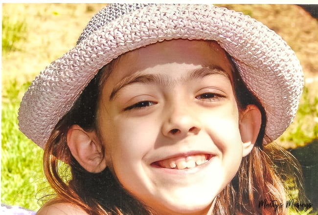 young girl in pink hat outside