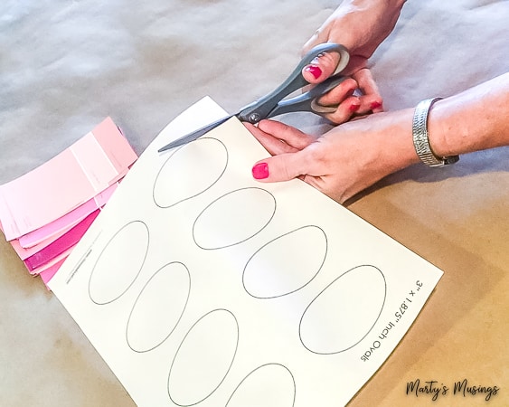 cutting out ovals next to pink paint chips