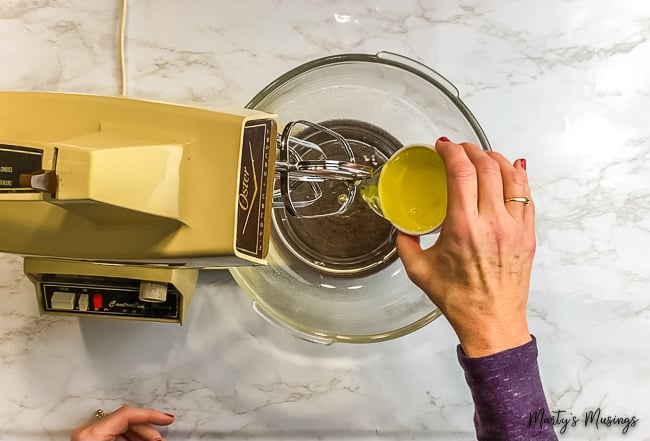 woman pouring egg whites into vintage mixer