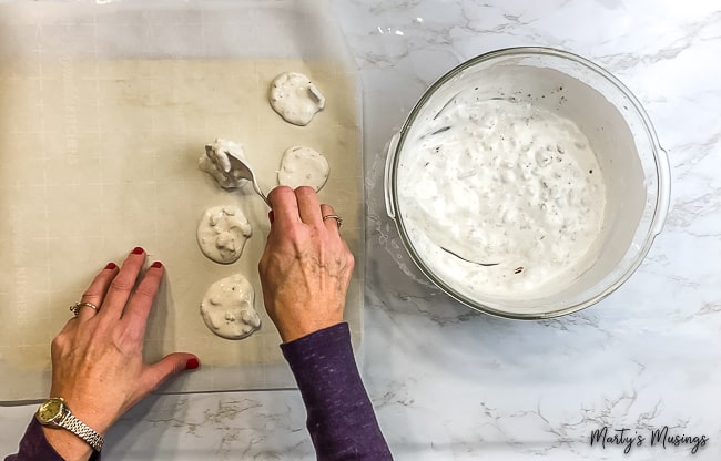 woman placing Easter Resurrection Cookies onto parchment paper