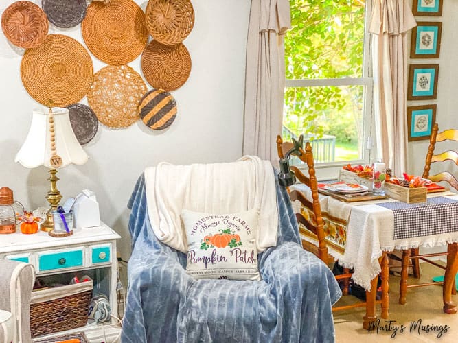 Basket wall and small corner decorated with covered chair and table for two decorated for fall